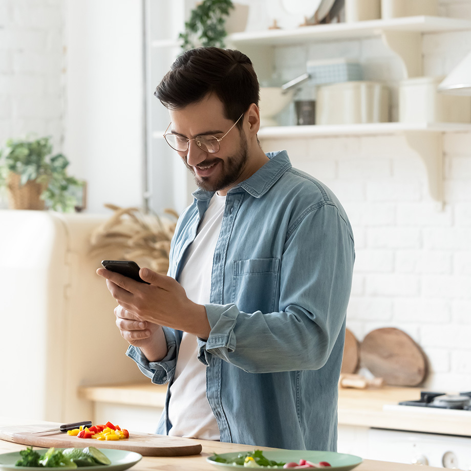 man using a smartphone in the kitchen